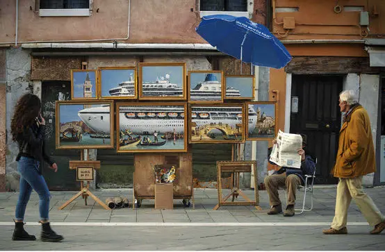 Foto dell'installazione dell'opera Venice in oil di Banksy in RIva degli Schiavoni a Venezia, con passanti.